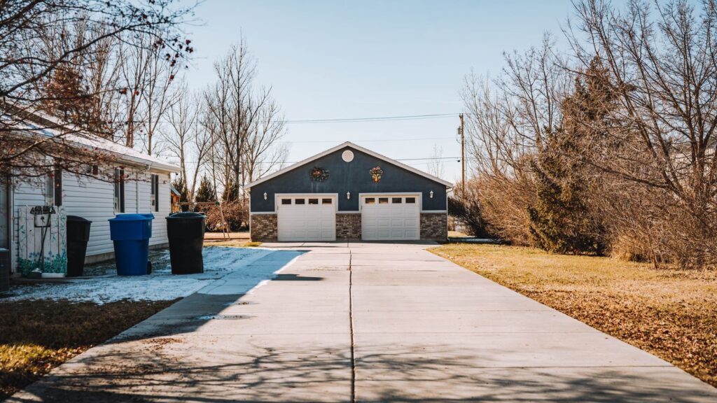 Spacious suburban driveway with house and garage in a peaceful neighborhood setting.