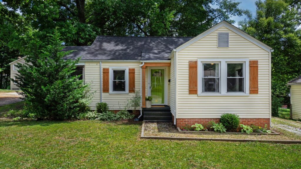 Front view of a quaint single-story house with garden landscaping.